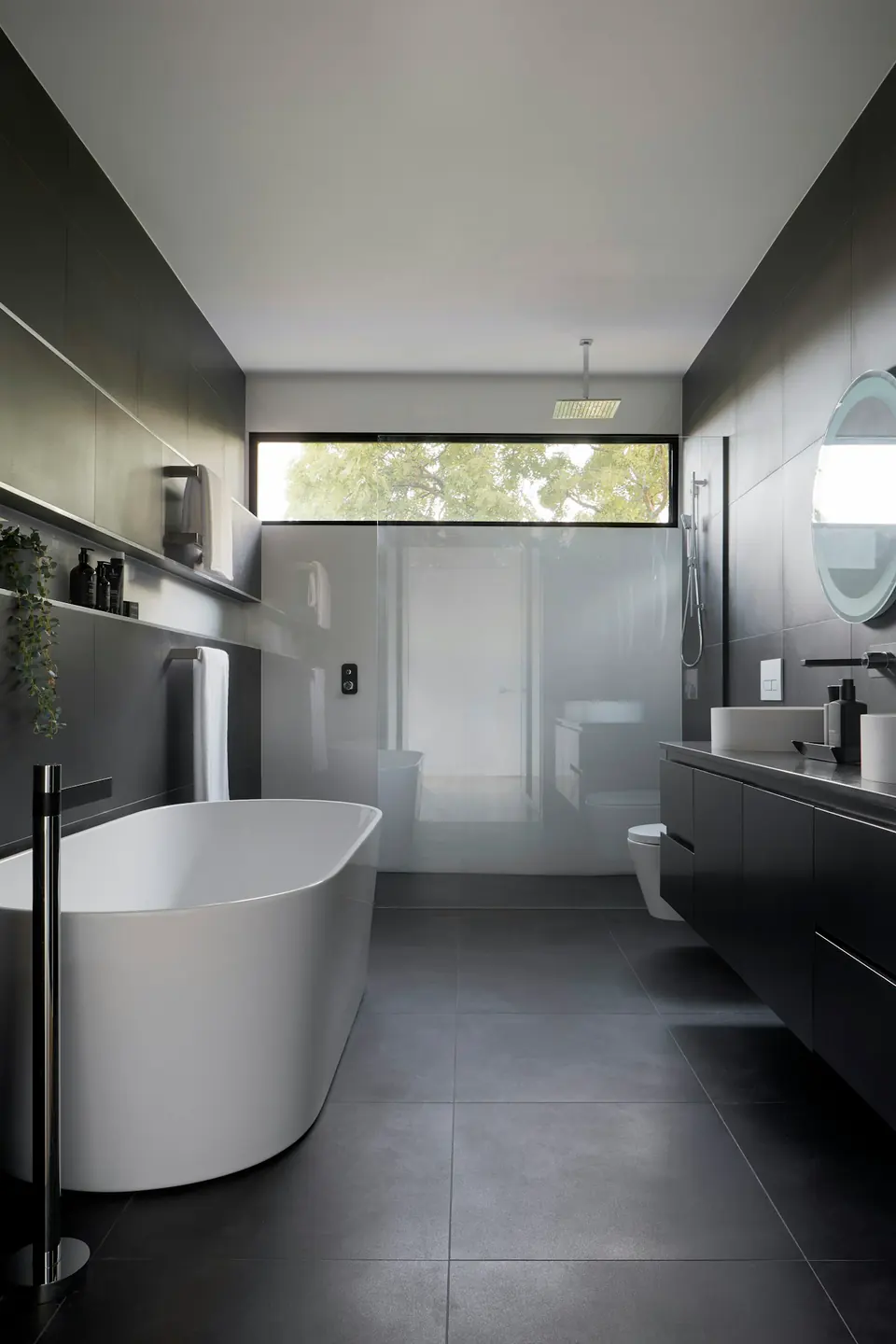 A quiet stone bathroom with a view towards greenery